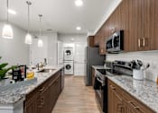Thumbnail 30 of 56 - A modern kitchen with dark wood cabinets and granite countertops.