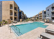 Thumbnail 6 of 56 - A swimming pool surrounded by apartment buildings.