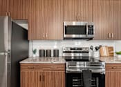 Thumbnail 21 of 56 - A modern kitchen with wooden cabinets and stainless steel appliances.