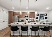 Thumbnail 37 of 56 - A modern kitchen with a dining table set for four.