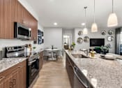 Thumbnail 32 of 56 - A modern kitchen with dark wood cabinets and stainless steel appliances.
