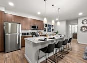 Thumbnail 50 of 56 - A modern kitchen with a large island and stainless steel appliances.