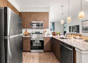 Thumbnail 49 of 56 - A modern kitchen with a refrigerator on the left and a sink on the right.