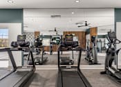 Thumbnail 20 of 56 - A gym with treadmills and elliptical machines.