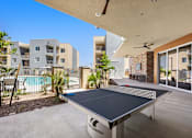 Thumbnail 3 of 56 - A table tennis table is in the middle of a patio.
