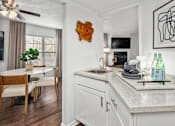 Thumbnail 47 of 51 - A kitchen with a white countertop and a wooden chair.