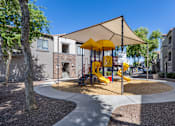 Thumbnail 12 of 29 - A playground with a yellow slide and a canopy.