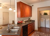 Thumbnail 40 of 51 - a kitchen with granite countertops and wooden cabinets