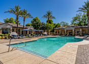 Thumbnail 2 of 24 - A swimming pool surrounded by palm trees and lounge chairs.