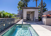Thumbnail 2 of 29 - A pool with a blue tiled wall and a white building in the background.