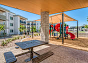 Thumbnail 43 of 56 - A playground with a red slide and a picnic table.