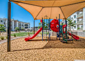 Thumbnail 42 of 56 - A playground with a red slide and a yellow canopy.