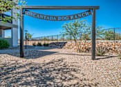 Thumbnail 44 of 56 - A sign that reads "Uncantada Dog Ranch" stands in front of a fence.