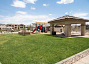 Thumbnail 32 of 34 - A playground with a red slide and a brown pavilion.