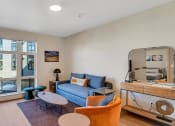 Thumbnail 21 of 53 - a living room with a blue couch and two orange chairs and a television