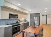 Thumbnail 22 of 53 - a kitchen with stainless steel appliances and a wooden table