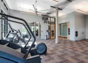 Thumbnail 47 of 53 - a gym with cardio equipment in a room with pillars