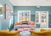 Thumbnail 10 of 34 - a living room with blue walls and a couch and chairs