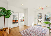 Thumbnail 8 of 34 - a living room with white walls and glass doors and a rug