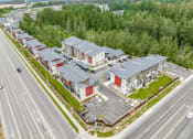 Thumbnail 29 of 30 - arial view of a row of houses with parking lot and trees in the background