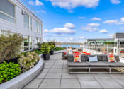 Thumbnail 3 of 22 - a seating area on the roof of a building with a view of the water