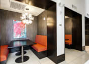 Thumbnail 18 of 22 - a dining area with a black table and orange chairs