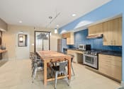 Thumbnail 15 of 20 - a kitchen with a wooden dining table and stainless steel appliances