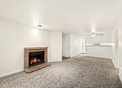 Thumbnail 7 of 26 - A room with a fireplace and carpeted floor.