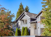Thumbnail 1 of 24 - a gray house with trees and a blue sky