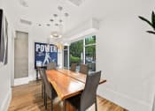 Thumbnail 26 of 27 - a dining room with a wooden table and chairs and a large window
