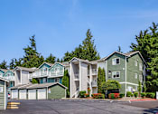 Thumbnail 1 of 34 - A row of houses with a clear blue sky above them.