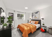Thumbnail 12 of 24 - a bedroom with white walls and an orange bed