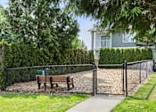 Thumbnail 16 of 34 - A park bench sits in front of a chain link fence.