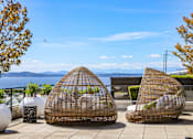 Thumbnail 32 of 38 - two rattan chairs sitting on a patio overlooking the water