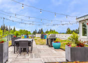 Thumbnail 3 of 20 - a backyard patio with tables and chairs and string lights