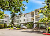 Thumbnail 5 of 34 - Apartment complex with green trees in front.