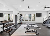 Thumbnail 7 of 32 - A spacious gym with a variety of equipment including treadmills, stationary bikes, and dumbbells.