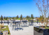 Thumbnail 33 of 53 - an outdoor patio with bar stools and tables overlooking the mountains