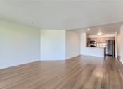 Thumbnail 10 of 33 - the living room and kitchen of an empty apartment with wood flooring