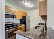 Thumbnail 6 of 33 - a kitchen with granite counter tops and stainless steel appliances