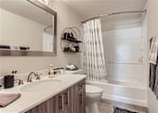 Thumbnail 13 of 33 - a bathroom with a shower and a sink and a toilet