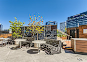 Thumbnail 33 of 33 - a roof terrace with benches and tables and a building in the background