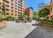 Thumbnail 23 of 33 - a courtyard between two buildings with benches and trees