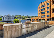 Thumbnail 31 of 33 - the rooftop barbecue area of a building with a city in the background