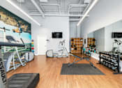 Thumbnail 25 of 38 - a workout room with weights and cardio equipment and a wall mural