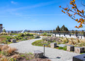 Thumbnail 40 of 53 - a park with a path and plants and a bridge