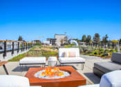 Thumbnail 51 of 53 - a patio with couches and a fire pit