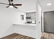 Thumbnail 6 of 13 - A modern kitchen with a fan and wooden floors.