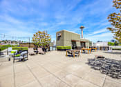 Thumbnail 28 of 38 - a patio with chairs and tables and a building in the background
