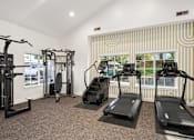 Thumbnail 9 of 38 - A gym with treadmills, a weight machine, and a stair climber.